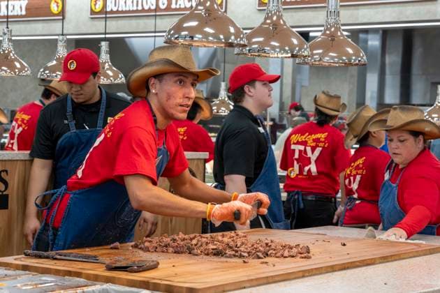 August 12, 2026, San Marcos, Tx, United States: An employee chops brisket as Texas Governor Greg Abbott (not shown) speaks during the opening of another 76,000 square foot Buc-ee s convenience store in San Marcos, Texas on August 12, 2026. The store features beaver-themed merchandise, lots of food choices and 124 gas pumps. San Marcos United States  - ZUMAd150 20260812_znp_d150_001 Copyright: xBobxDaemmrichx