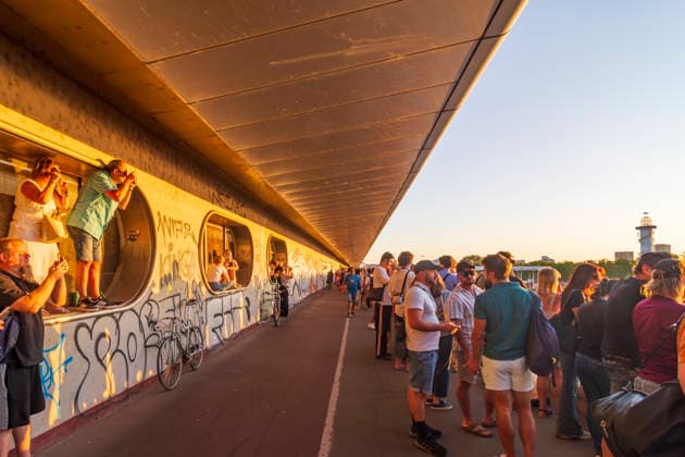 people with eclipse glasses watching partial solar eclipse on bridge Reichsbrücke, at subway U1 station entrance Donauinsel Vienna 22. Donaustadt Wien Austria