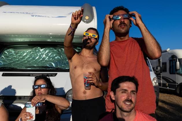 August 12, 2026, Paredes De Coura, Braga, Portugal: A group of festivalgoers wearing certified eclipse glasses watch the partial solar eclipse from the festival grounds during the opening day of Vodafone Paredes de Coura. Paredes De Coura Portugal  - ZUMAs197 20260812_aaa_s197_599 Copyright: xDiogoxBaptistax