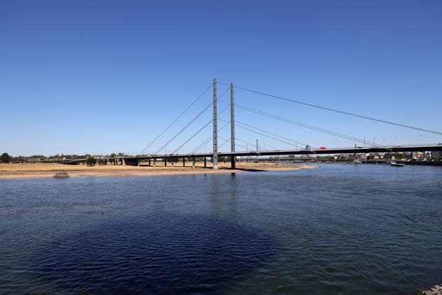 August 13, 2026, Germany, North Rhine-Westphalia, Weather, Heat, Rivers, Low Water Levels, Drought, Due to the heat, the water level of the Rhine in Düsseldorf has dropped significantly, which is becoming increasingly problematic for ships, Rheinknie Bridge, Germany Copyright: xD.xKerlekin SnowfieldxPhotographyx SF130826RheinD3