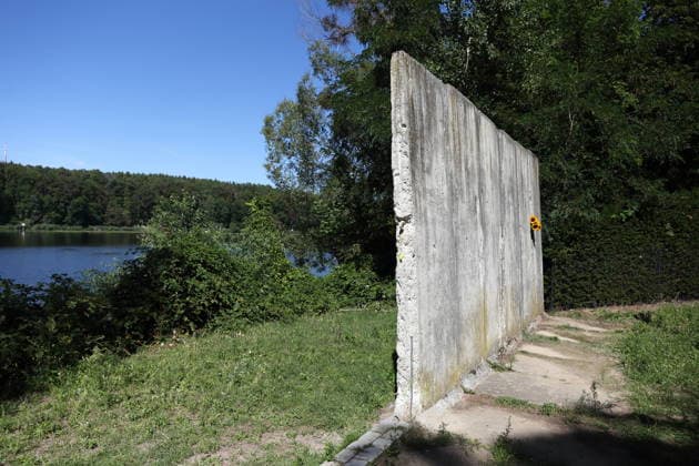 Sunflowers are placed in a segment of the Berlin Wall at the Wall Memorial on Griebnitzsee in Potsdam to mark the 65th anniversary of the construction of the Berlin Wall, August 13, 2026—65 years since the Wall was built