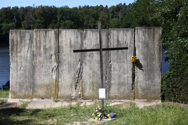 Sunflowers are placed in a segment of the Berlin Wall at the Wall Memorial on Griebnitzsee in Potsdam to mark the 65th anniversary of the construction of the Berlin Wall, August 13, 2026—65 years since the Wall was built