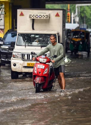 Heavy rain lashes parts of the National Capital New Delhi, Aug 13 (ANI): Commuters wade through a waterlogged road near SIR M. Vishweshwariah Moti Bagh metro station following heavy rainfall, in New Delhi on Thursday. New Delhi Delhi India Copyright: xANIx ANI_20260813263