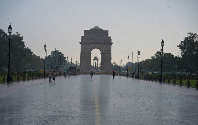 Heavy rain lashes parts of the National Capital New Delhi, Aug 13 (ANI): Visitors with umbrellas stand near India Gate amid heavy rainfall, in New Delhi on Thursday. New Delhi Delhi India Copyright: xANIx ANI_20260813296