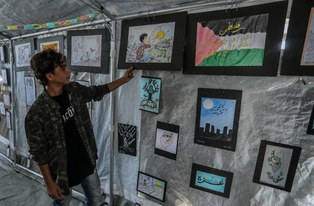 Palestinian children reflect war, displacement and hope through Art in Khan Yunis KHAN YUNIS, GAZA , PALESTINE - AUGUST 13: Works by Palestinian children are brought together in the exhibition held inside a tent at a refugee camp in the Al-Mawasi area of Khan Yunis, Gaza, Palestine on August 13, 2026. Created amid the severe humanitarian conditions resulting from the attacks that have continued since Oct. 2023, the artworks depict the children s experiences of displacement, destruction, hunger, water shortages and the loss of loved ones. Abed Rahim Khatib Anadolu Han Yunus Palestinian Territory, Occupied. Editorial use only. Please get in touch for any other usage. Copyright: x2026xAnadoluxAbedxRahimxKhatibx