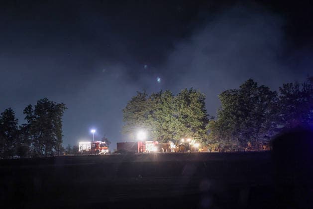 Marsberg, North Rhine-Westphalia, Germany, Europe Fire trucks and heavy-duty clearing equipment stand by during a nighttime forest fire operation near the Diemel Dam. Bright work lights and rising smoke characterize the scene as firefighters continue their efforts to extinguish the blaze and secure the affected forest area. Copyright: xAymanxAlahmedx