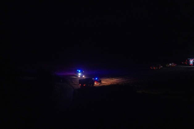 Helminghausen, Marsberg, North Rhine-Westphalia, Germany, Europe Fire trucks with their blue lights flashing drive along and position themselves on a dirt road at the edge of the operation area during a nighttime forest fire response. The photo shows the expansive staging area and the ongoing deployment of emergency personnel as part of the effort to Copyright: xAymanxAlahmedx