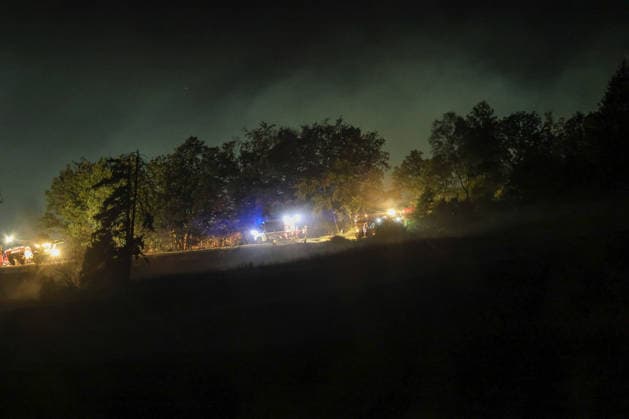 Marsberg, North Rhine-Westphalia, Germany, Europe: Firefighters are battling a forest fire near the Diemel Dam overnight. Several fire trucks and emergency crews are on the scene along the edge of the forest, while smoke rises above the trees. Blue lights, floodlights, and emergency vehicles dominate the nighttime scene as firefighters continue to battle the bla Copyright: xAymanxAlahmedx