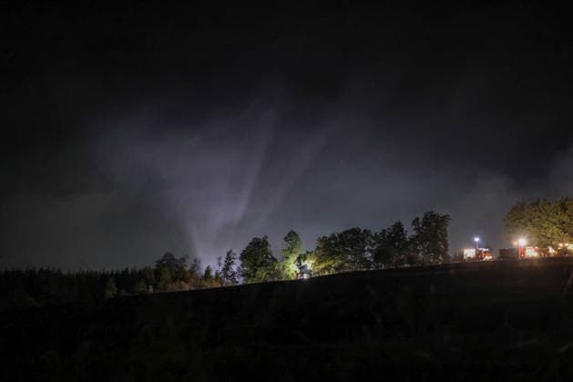 Marsberg, North Rhine-Westphalia, Germany, Europe Wide-angle shot of a nighttime forest fire operation near the Diemel Dam A striking column of smoke rises above the forest and is illuminated by the fire department’s powerful spotlights Emergency vehicles are operating along the edge of the forest as firefighting efforts continue through the night Copyright: xAymanxAlahmedx