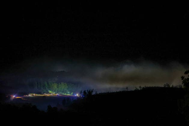 Helminghausen, Marsberg, North Rhine-Westphalia, Germany, Europe: Thick smoke rises above the forest during a nighttime wildfire operation near the Diemel Dam; fire trucks and emergency personnel are working along the edge of the forest, while spotlights and blue lights illuminate the extensive scene of the operation Copyright: xAymanxAlahmedx