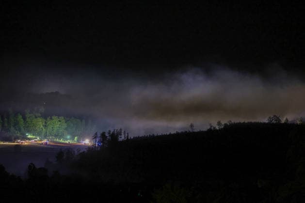 Helminghausen, Marsberg, North Rhine-Westphalia, Germany, Europe A vast cloud of smoke hangs over the forest area during a nighttime wildfire operation near the Diemel Dam. Fire trucks and emergency responders are working along the edge of the forest, while floodlights and blue lights illuminate the extensive scene of the operation. Copyright: xAymanxAlahmedx