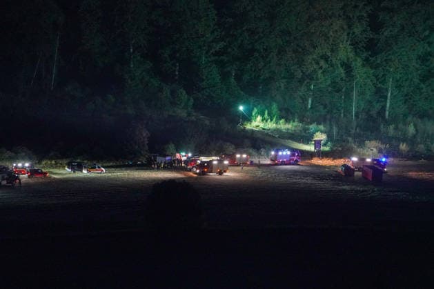 Helminghausen, Marsberg, North Rhine-Westphalia, Germany, Europe Fire trucks and emergency personnel set up a staging area in an open space at the edge of the forest during a nighttime forest fire operation. Mobile floodlights illuminate the scene, while incident command and fire trucks coordinate the large-scale firefighting operation. Copyright: xAymanxAlahmedx