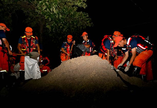 (260814) -- JIAXIAN, Aug. 14, 2026 -- Rescuers work at the site of a levee breach along the Beiru River in Jiaxian County, central China s Henan Province, Aug. 13, 2026. A levee along the Beiru River in Jiaxian County gave way on Wednesday night, following extreme rainfall and large-volume discharges from upstream reservoirs. As of Thursday, a total of 2,182 people had been evacuated to safety, with no casualties reported so far. Efforts to contain the levee breach are underway. ) CHINA-HENAN-JIAXIAN COUNTY-LEVEE BREACH-REPAIR WORK (CN) HaoxYuan 