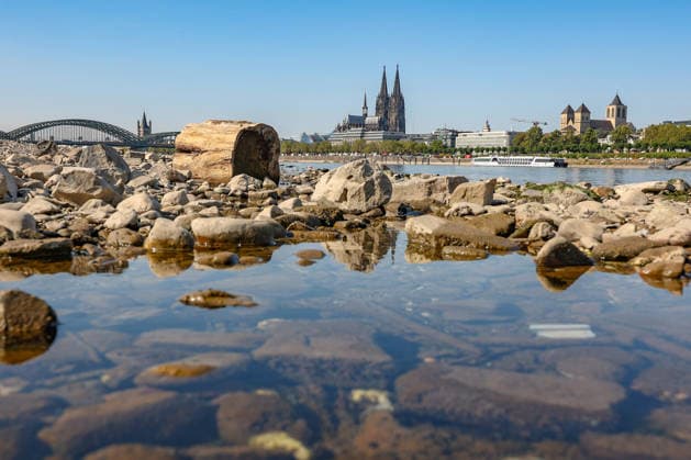 Summer in the Rhineland: View of the Rhine near Cologne (Deutz). The Rhine in Cologne is at low water levels due to persistent drought. In the background, the Hohenzollern Bridge is on the left and Cologne Cathedral is on the right. Summer in the Rhineland on August 14, 2026 in Cologne, Germany