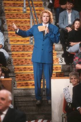 Thomas Gottschalk, TV host, 11, 91 pp. Thomas Gottschalk on *Wetten,* dass on ZDF on November 2, 1991, in Basel TV television TV show show Germany German German man host hosting TV host actor entertainer German host presenter standing tall holding a microphone gesturing speaking holding cards audience