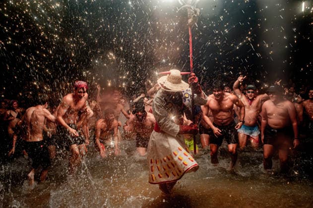 August 15, 2026, Badalona, Spain: People react as a Correfoc devil enters the sea during the August Festival in Badalona, north of Barcelona. The Correfoc, a traditional Catalan celebration featuring fireworks and fire-spitting performers, ends in the waters of Badalona beach. Badalona Spain - ZUMAb137 20260815_fap_b137_006 Copyright: xJordixBoixareux