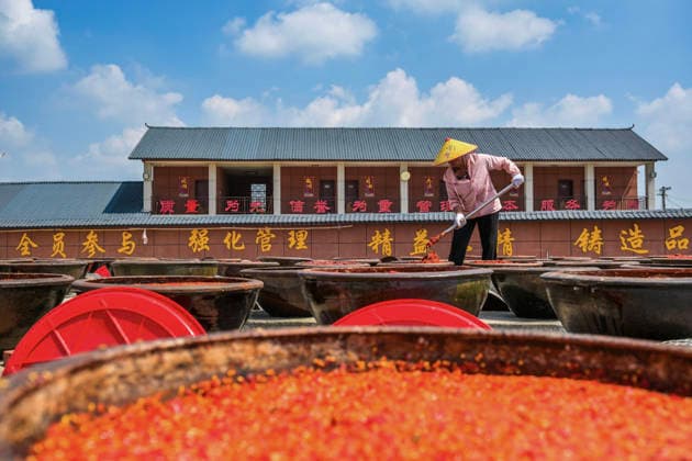 (260816) -- SHUANGFENG, Aug. 16, 2026 -- A staff member operates at an airing field for chili sauce in Yongfeng Subdistrict of Shuangfeng County, Loudi City of central China s Hunan Province, Aug. 16, 2026. As one of China s protected geographical indication products, chili sauce made in Yongfeng Subdistrict boasts a history of several centuries. (Photo by Xinhua) CHINA-HUNAN-SHUANGFENG-CHILI SAUCE-PREPARATION (CN) LixJianxin 