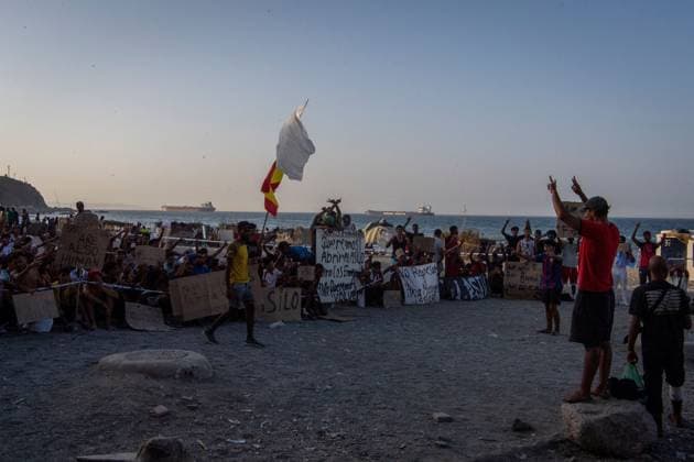 August 17, 2026, Ceuta, Spain: CEUTA, SPAIN Ã¢â‚¬ AUGUST 17, 2026: More than 100 migrants, most of them Moroccan, have been protesting for days in front of National Police vans during the daily food distribution provided by the Spanish Red Cross at TrampoloÂ­n Beach. Ã¢â‚¬oeNo asylum, no foodÃ¢â‚¬Â is the chant repeated by the migrants on the sand, while African migrants continue to stay in the temporary accommodation facilities set up on the Ceuta beach. Authorities are expected to clear the beach in the coming days and transfer the migrants to four reception facilities announced today by SpainÃ¢â‚¬â ¢s Minister for Migration, Elma Saiz. Ceuta Spain  - ZUMAq101 20260817_zna_q101_082 Copyright: xAntonioxSemperex
