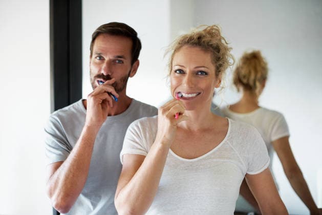 Portrait, morning and couple in bathroom for brushing teeth, hygiene and dental wellness together. Mirror, home and man with woman with toothbrush for health, cleaning and bonding for daily routine. model released property released Copyright: xAMVx