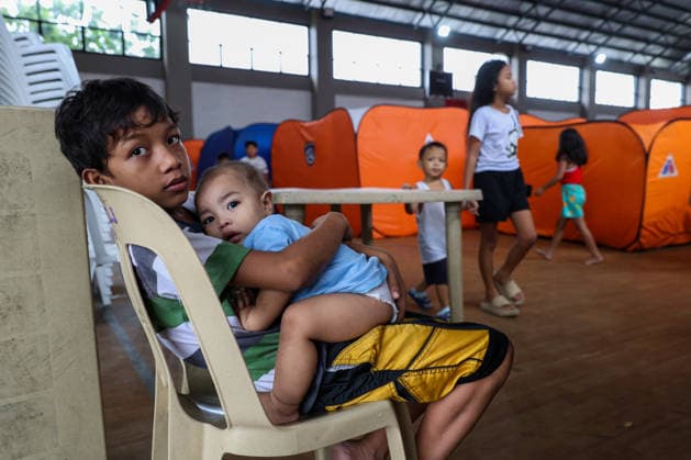 Tens of thousands evacuated in Philippines amid monsoon rains, floods QUEZON CITY, PHILIPPINES: A boy and his little brother evacuated from flooded areas take shelter at a secondary school basketball court, amid lingering threats of flooding caused by heavy monsoon rains, in Quezon City, Metro Manila, Philippines, on August 18, 2026. As the country remains threatened by floods caused by monsoon heavy rains, tens of thousands of people in the capital region of Metro Manila and its surrounding cities and areas have been evacuated, with schools in multiple locations across the Philippines being suspended for safety reasons. Daniel Ceng Anadolu Quezon City Philippines. Editorial use only. Please get in touch for any other usage. Copyright: x2026xAnadoluxDanielxCengx