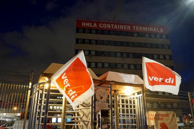CNTV VERDI Everything is ready. Red and white VERDI flags are hanging at the Burchardkai Container Terminal in the Port of Hamburg for the warning strike by port workers and employees. On the night of August 17, 2026, in the Port of Hamburg. Slogan: 24-hour, 3-shift warning strike during collective bargaining for seaports—VERDI calls for a w