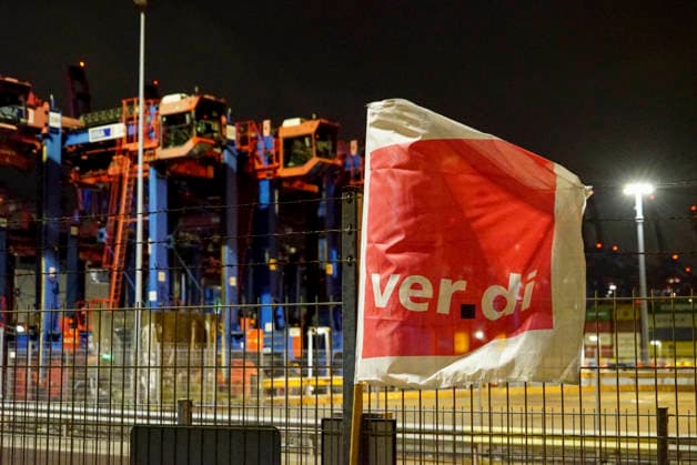 CNTV VERDI Everything is ready. Red and white VERDI flags are hanging at the Burchardkai Container Terminal in the Port of Hamburg for the warning strike by port workers and employees. On the night of August 17, 2026, in the Port of Hamburg. Slogan: 24-hour, 3-shift warning strike during collective bargaining for seaports—VERDI calls for a w