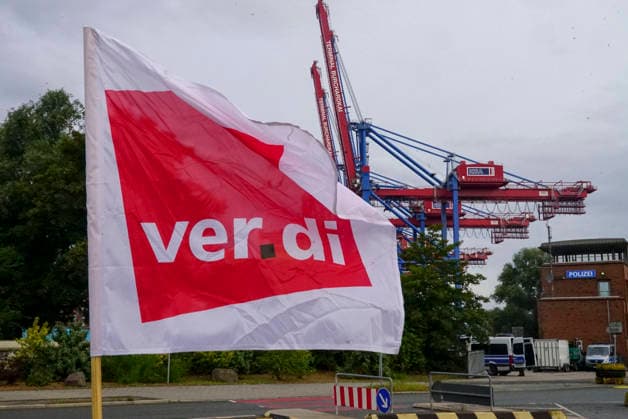 CNTV VERDI Striking workers with red-and-white VERDI flags at the Port of Hamburg; Port of Hamburg at the Burchardkai Container Terminal; warning strike by port workers on August 18, 2026, at the Port of Hamburg; slogan: 24 hours, 3 shifts ; warning strike during collective bargaining negotiations for seaports; VERDI VERDI calls for a 24-hour warning strike at the P