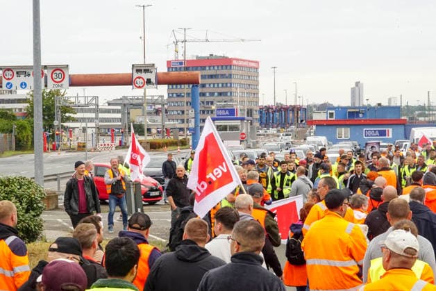 CNTV VERDI Striking workers with red-and-white VERDI flags at the Port of Hamburg; Port of Hamburg at the Burchardkai Container Terminal; warning strike by port workers on August 18, 2026, at the Port of Hamburg; slogan: 24 hours, 3 shifts ; warning strike during collective bargaining negotiations for seaports—VERDI VERDI calls for a 24-hour warning strike at the Po
