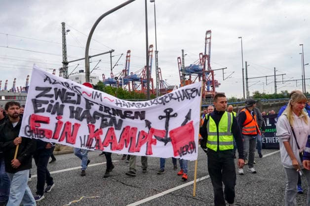 CNTV VERDI Striking workers with red-and-white VERDI flags at the Port of Hamburg; Port of Hamburg at the Burchardkai Container Terminal; warning strike by port workers on August 18, 2026, at the Port of Hamburg; slogan: 24 hours, 3 shifts ; warning strike during collective bargaining negotiations for seaports—VERDI VERDI calls for a 24-hour warning strike at the Po