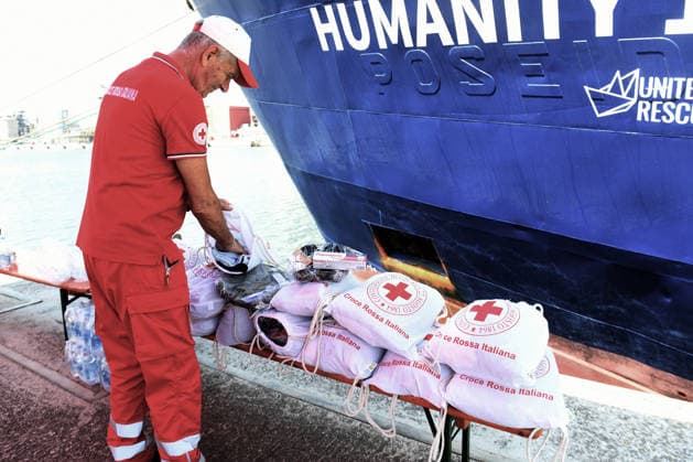 August 18, 2026, Ravenna, Rome, Italy: The NGO ship Humanity 1 has arrived in the port of Ravenna with 73 migrants on board, 15 of whom are minors and five women, one of whom is a minor. Most are from Sudan, with others from Senegal. This is the 28th landing in the port of Ravenna. In the photo, a Red Cross worker arranges the bags containing first aid items such as slippers, soap, toothpaste, and clothing to be distributed to all the migrants. Ravenna Italy - ZUMAa289 20260818_zia_a289_019 Copyright: xAgfx