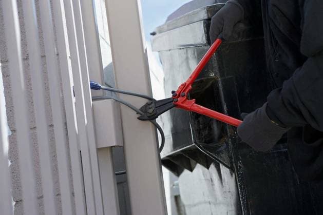 Closeup of a thief s hands cutting wire with cutter to open the gate model released Symbolfoto Copyright: xmoodboardx Panthermedia75375886.jpg
