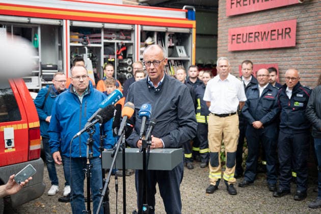 Visit by the Federal Chancellor to the Huertgenwald wildfire area: Federal Chancellor Friedrich Merz and District Administrator Dr. Ralf Nolten (left) during their joint press statement, with emergency responders in the background, as part of his visit to the Huertgenwald wildfire area to thank the emergency responders. Huertgenwald, August 22, 2026, Huertgenwald, North Rhine-Wes