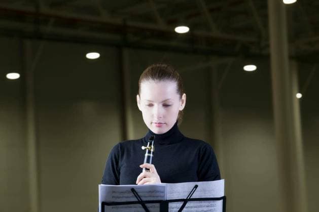 Beautiful clarinet player looking at music sheet under spotlights model released Symbolfoto Copyright: xmoodboardx Panthermedia75451506.jpg