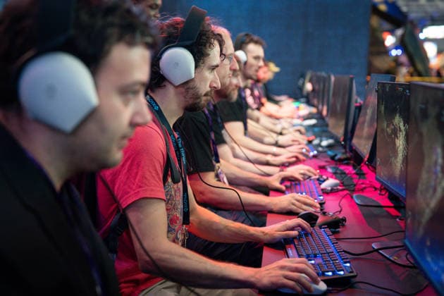 Gamescom 2026: Gamescom kicks off today with its trade visitor day. The world s largest trade show for computer and video games takes place in Cologne. Stock photo of gamers wearing headphones in front of monitors, trying out the latest video game trends. Cologne, North Rhine-Westphalia, Germany
