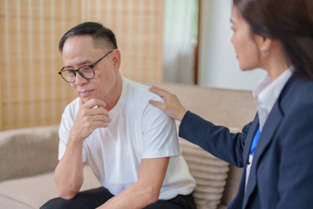 Ein Berater legt einem besorgten älteren asiatischen Mann die Hand auf die Schulter, um ihn psychisch zu unterstützen und ihm Trost zu spenden An empathetic therapist comforting a stressed Asian elderly man by placing a hand on his shoulder during a counseling session. (License=RF) ,model released, Symbolfoto Copyright: xZoonar.com WORAWEExMEEPIANx 25502654 ,model released, Symbolfoto ,property released