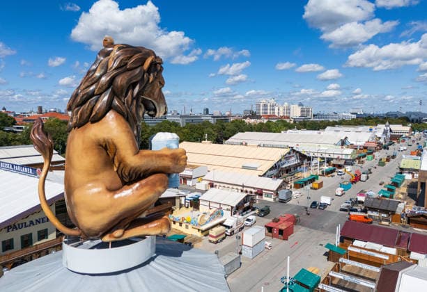 MÜNCHEN, DEUTSCHLAND, 29. AUGUST 2026 Aufbau des Oktoberfestes mit Löwenstatue und Bierzelten Eine große Löwenstatue, die einen Bierkrug in der Hand hält, überragt die Theresienwiese während der Aufbauarbeiten für das Oktoberfest 2026 in München, Deutschland Copyright: xx