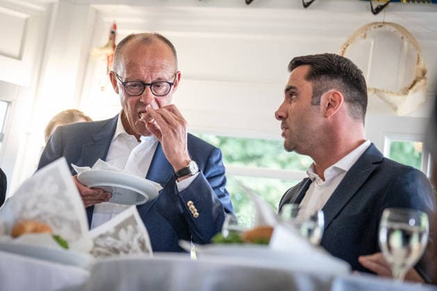 Eating a fish sandwich at the Fisch Hus fish shop on the beach promenade; Federal Chancellor Friedrich Merz eats a fish sandwich with Daniel Peters, the CDU’s top candidate for Federal Chancellor, during the campaign for the 2026 Mecklenburg-Western Pomerania state election in Kühlungsborn, Kühlungsborn, Mecklenburg-Western Pomerania, Germany LOCATION