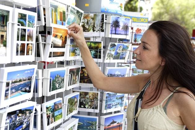 Frau vor Ansichtskartenständer auf Mallorca, Ansichtskarten, Souveniers Woman standing in front of a postcard stand on Majorca, postcards, souvenirs Copyright: imageBROKER McPHOTOx xBilderBox iblbhj18858670.jpg ,model released, Symbolfoto ,property released