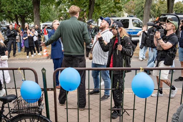 YouTuber and streamer Matthäus Westfal, known as Activist in the Blue Cap and Marcant in the Green Jacket, and Sebastian Weber, known as Weichreite TV in the Black Cap, on the sidelines of the AfD Democracy Festival campaign event in Haldensleben for the 2026 Saxony-Anhalt state election, Haldensleben, Saxony-Anhalt, Germany; the Schützenhaus of the Schützengilde