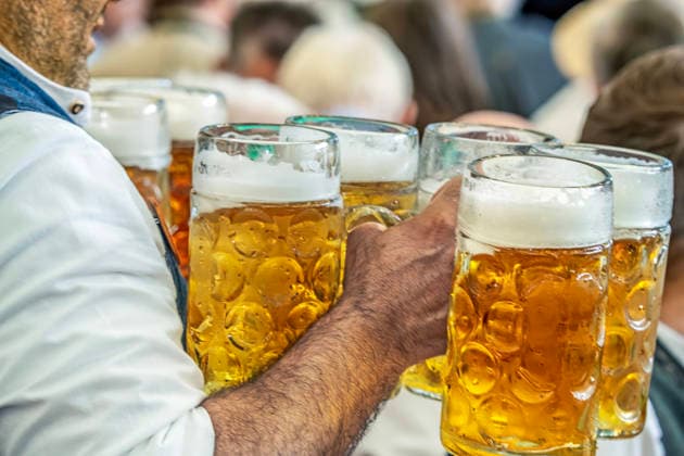 A server carries freshly poured liters of beer through the crowded festival tent at the Gillamoos folk festival in Abensberg, September 7, 2026, Germany, Abensberg, September 7, 2026: A server carries freshly poured liters of beer through the crowded festival tent, he is carrying 5 full Maß mugs in each hand—Helles and Radler—beer and camarade