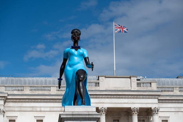 September 12, 2026, London, United Kingdom: Sculpture Lady in Blue with the British Flag in the background in Trafalgar Square, London. Lady in Blue, a bronze sculpture by New York-based artist Tschabalala Self, stands on the Fourth Plinth in Trafalgar Square, London. Unveiled on 10 September, the work pays homage to a young metropolitan woman of colour and was created as a contemporary everywoman representing the diversity of London today. The sculpture explores themes of representation, recognition and equity, presenting an everyday woman walking forward into a shared future rather than a traditional historical figure or monument. The bronze sculpture is patinated in Lapis Lazuli blue, a pigment with a long history across North Afri - ZUMAs197 20260912_aaa_s197_277 Copyright: xAndreaxDomeniconix