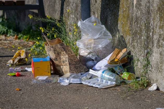 Trash against a wall on the banks of the Rhine, Wörth am Rhein, Germany, September 14, 2026. Plastic bags, packaging, bottles, and cardboard boxes lie carelessly discarded against a concrete wall on the banks of the Rhine. An illustrative image of littering and illegal trash disposal.