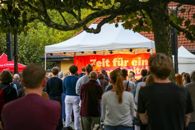 Berlin, Germany, September 15, 2026. Numerous participants are watching a rally organized by the party Die Linke at Mierendorffplatz in Berlin’s Charlottenburg district. The scene includes a stage, party tents, and a vest bearing the slogan Make Berlin Affordable. Speakers at the event include Heidi Reichinnek, Elif Eralp, and Niklas Schenker. The topic is ho Copyright: xAlonxDavidx