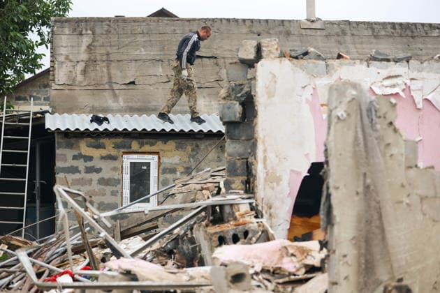 RUSSIA, DONETSK PEOPLE S REPUBLIC - SEPTEMBER 16, 2026: A man removes debris from a house destroyed by a drone strike in Zolotorevka. Dmitry Yagodkin TASS  97818111
