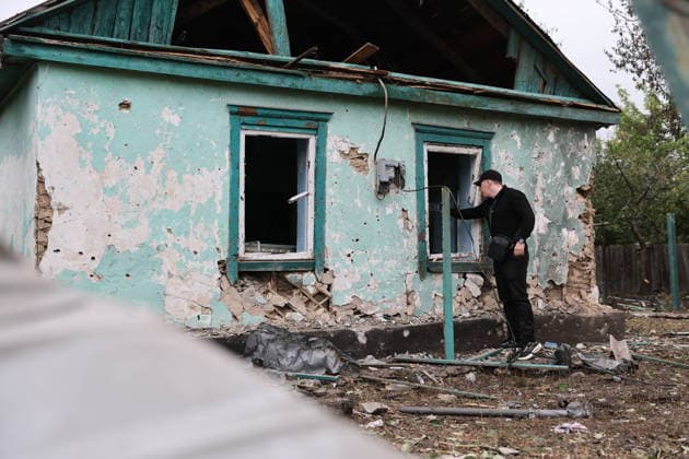RUSSIA, DONETSK PEOPLE S REPUBLIC - SEPTEMBER 16, 2026: A man records the destruction in a house hit by a drone strike in Zolotorevka. Dmitry Yagodkin TASS  97818292