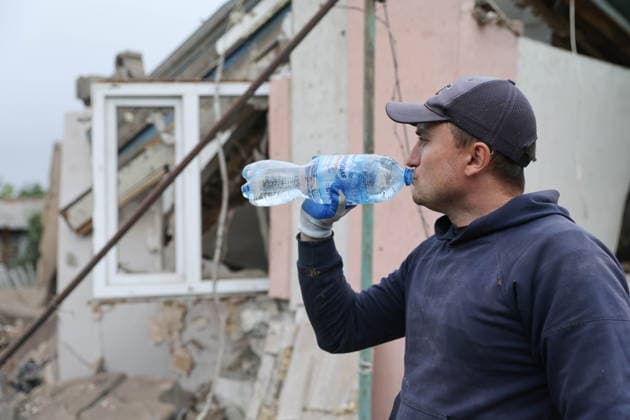 RUSSIA, DONETSK PEOPLE S REPUBLIC - SEPTEMBER 16, 2026: A man drinks water near a house destroyed a drone strike in Zolotorevka Russia  - ZUMAt113 20260916_zaa_t113_348 Copyright: xDmitryxYagodkinx