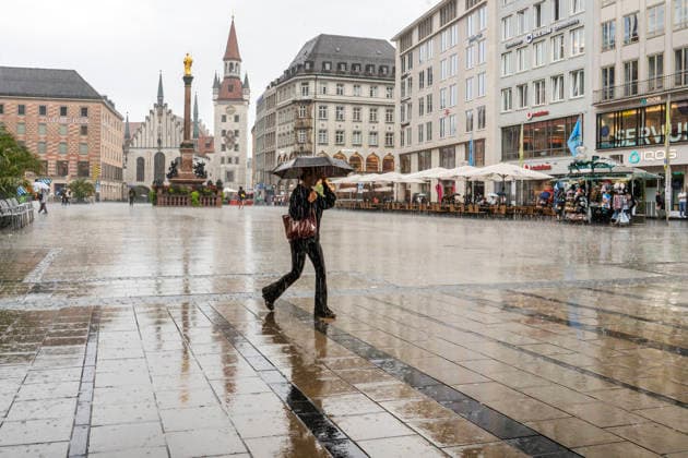 A woman hurries across the empty Marienplatz with her umbrella; heavy rain on a Wednesday afternoon, Munich, September 16, 2026, Germany, Munich, September 2026, a passerby hurries across the empty Marienplatz with her umbrella; heavy rain on a Wednesday afternoon, downtown, pedestrian zone, downpour, rainy weather at 21 degrees, r