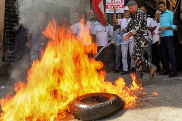 September 17, 2026, Beirut, Beirut, Lebanon: A Lebanese policeman douse burned tire set by depositors outside the ministry of Economy in Beirut during a protest by investors who are still unable to withdraw their foreign-currency savings. Depositors called on the government and Parliament to adopt a fair plan to recover their funds. Demonstrators clashed with security forces guarding a bank leaving several people injured among the protesters. Beirut Lebanon  - ZUMAn313 20260917_zip_n313_011 Copyright: xMarwanxNaamanix