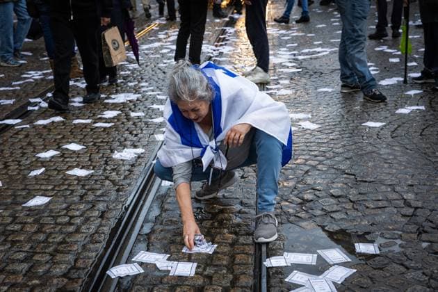 AMSTERDAM - A woman clears away pro-Palestine pamphlets during a national demonstration on Dam Square organized by the working group Op de Bres voor IsraÃ«l together with other organizations. A counter-demonstration has also been announced. DINGENA MOL ANP netherlands out - belgium out  Copyright: xx x569010324x originalFilename: 569010324.jpg