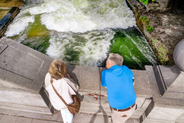Störung an der Münchner Eisbachwelle, die berühmte Surfwelle ist seit gestern verschwunden, nach einem starken Anstieg des Wasserstands bildete sich nur noch gefährliches Weißwasser, Blick von der Brücke, München, 18. September 2026 Deutschland, München, 18. September 2026, Störung an der Münchner Eisbachwelle, die berühmte Surfwelle ist seit gestern verschwunden, nach einem starken Anstieg des Wasserstands bildete sich nur noch gefährliches Weißwasser, Touristen auf der Brücke wundern sich: kein Surfer an der berühmten Eisbachwelle, und das ausgerechnet vor Beginn des Oktoberfests, der Pegel wird inzwischen wieder abgesenkt, wann sich erneut eine surfbare Welle bildet, ist nicht vorherzusagen, ob morgen oder erst in einer